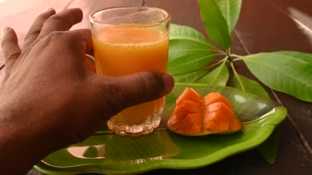 芒果汁与芒果片分离的黑色背景 芒果摇动 一杯新鲜的芒果汁 这是印地安人夏天最受欢迎的传统饮料 — 图库视频影像