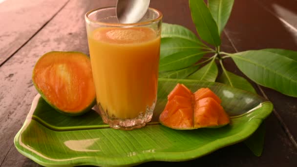黒を基調としたマンゴースライスのマンゴージュース マンゴーシェイク フレッシュマンゴージュースのグラス これは 夏にインドの伝統的で最も人気のある飲み物です — ストック動画