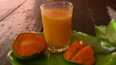 Siyah arka planda izole edilmiş mango dilimli mango suyu. Mango karışımı. Bir bardak taze mango suyu. Bu yazın Hindistan 'ın geleneksel ve en popüler içkisidir. Yavaş çekim videosu.