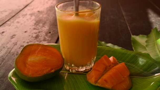 黒を基調としたマンゴースライスのマンゴージュース マンゴーシェイク フレッシュマンゴージュースのグラス これは夏の伝統的で最も人気のあるインドの飲み物です スローモーションビデオ — ストック動画
