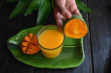 Siyah arka planda izole edilmiş mango dilimli mango suyu. Mango karışımı. Bir bardak taze mango suyu. Bu yazın Hindistan 'ın geleneksel ve en popüler içkisidir..