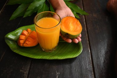 Siyah arka planda izole edilmiş mango dilimli mango suyu. Mango karışımı. Bir bardak taze mango suyu. Bu yazın Hindistan 'ın geleneksel ve en popüler içkisidir..