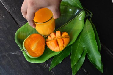 Siyah arka planda izole edilmiş mango dilimli mango suyu. Mango karışımı. Bir bardak taze mango suyu. Bu yazın Hindistan 'ın geleneksel ve en popüler içkisidir..