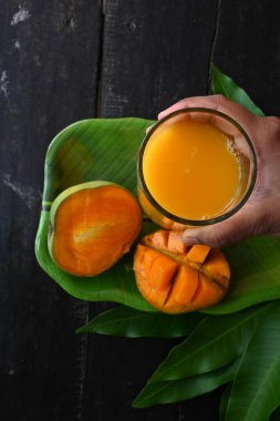 Siyah arka planda izole edilmiş mango dilimli mango suyu. Mango karışımı. Bir bardak taze mango suyu. Bu yazın Hindistan 'ın geleneksel ve en popüler içkisidir..