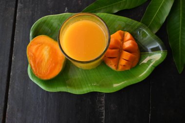 Siyah arka planda izole edilmiş mango dilimli mango suyu. Mango karışımı. Bir bardak taze mango suyu. Bu yazın Hindistan 'ın geleneksel ve en popüler içkisidir..