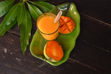 Siyah arka planda izole edilmiş mango dilimli mango suyu. Mango karışımı. Bir bardak taze mango suyu. Bu yazın Hindistan 'ın geleneksel ve en popüler içkisidir..