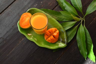Siyah arka planda izole edilmiş mango dilimli mango suyu. Mango karışımı. Bir bardak taze mango suyu. Bu yazın Hindistan 'ın geleneksel ve en popüler içkisidir..