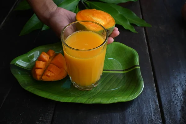 黒を基調としたマンゴースライスのマンゴージュース マンゴーシェイク フレッシュマンゴージュースのグラス これは 夏にインドの伝統的で最も人気のある飲み物です — ストック写真