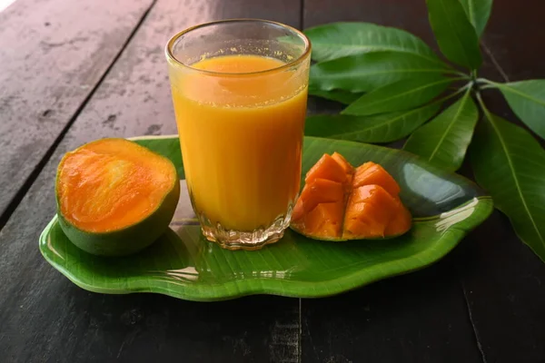 黒を基調としたマンゴースライスのマンゴージュース マンゴーシェイク フレッシュマンゴージュースのグラス これは 夏にインドの伝統的で最も人気のある飲み物です — ストック写真