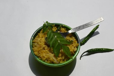 Vegetable Poha in India. It is made by mixing vegetables, poha and spices. Rice is parboiled before flattening so that it can be consumed with very little to no cooking. Indian breakfast.