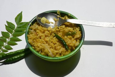 Vegetable Poha in India. It is made by mixing vegetables, poha and spices. Rice is parboiled before flattening so that it can be consumed with very little to no cooking. Indian breakfast.