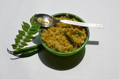 Vegetable Poha in India. It is made by mixing vegetables, poha and spices. Rice is parboiled before flattening so that it can be consumed with very little to no cooking. Indian breakfast.