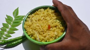 Vegetable Poha in India. It is made by mixing vegetables, poha and spices. Rice is parboiled before flattening so that it can be consumed with very little to no cooking. Indian breakfast.