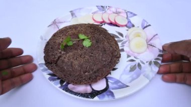 Eleusine coracana veya parmak darı chapati. Diğer isimleri Hindistan 'da Ragi ve Madua ve Nepal' de Kodo. Hint geleneksel Ragi roti veya düz ekmek. Madua roti veya düz ekmek. Beyaz arkaplanda çekilen.