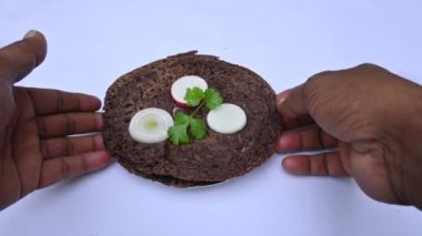 Eleusine coracana veya parmak darı chapati. Diğer isimleri Hindistan 'da Ragi ve Madua ve Nepal' de Kodo. Hint geleneksel Ragi roti veya düz ekmek. Madua roti veya düz ekmek. Beyaz arkaplanda çekilen.