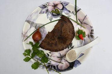 Eleusine coracana veya parmak darı chapati. Diğer isimleri Hindistan 'da Ragi ve Madua ve Nepal' de Kodo. Hint geleneksel Ragi roti veya düz ekmek. Madua roti veya düz ekmek. Beyaz arkaplanda çekilen.