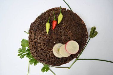 Eleusine coracana veya parmak darı chapati. Diğer isimleri Hindistan 'da Ragi ve Madua ve Nepal' de Kodo. Hint geleneksel Ragi roti veya düz ekmek. Madua roti veya düz ekmek. Beyaz arkaplanda çekilen.