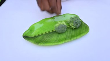 Beyaz arka planda brokoli. Diğer adı Brassica oleracea var italica. Bu lahana familyasından yenilebilir yeşil bir bitki. Brokoli özellikle zengin bir C ve K vitamini kaynağıdır..