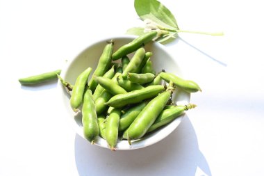 Beyaz arka planda Vicia Faba sebzesi. Diğer adı fasulye, fava fasülyesi, veya faba fasülyesi. Bu bir tür vejetaryendir. Bezelye ve fasulye familyasında çiçek açan bir bitki..