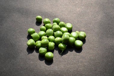 Siyah arka planda taze bezelye. İçinde bir sürü vitamin ve mineral var. Bezelye genellikle küçük bir kürenin tohumu olur. Dünyanın en popüler sebzesi.. 