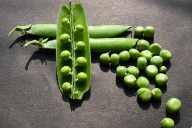 Siyah arka planda taze bezelye. İçinde bir sürü vitamin ve mineral var. Bezelye genellikle küçük bir kürenin tohumu olur. Dünyanın en popüler sebzesi.. 