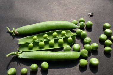 Siyah arka planda taze bezelye. İçinde bir sürü vitamin ve mineral var. Bezelye genellikle küçük bir kürenin tohumu olur. Dünyanın en popüler sebzesi.. 