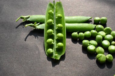 Siyah arka planda taze bezelye. İçinde bir sürü vitamin ve mineral var. Bezelye genellikle küçük bir kürenin tohumu olur. Dünyanın en popüler sebzesi.. 