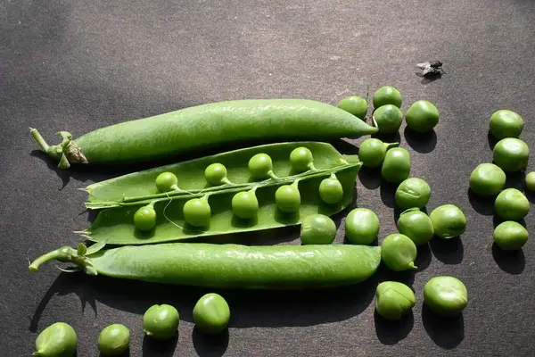 Siyah arka planda taze bezelye. İçinde bir sürü vitamin ve mineral var. Bezelye genellikle küçük bir kürenin tohumu olur. Dünyanın en popüler sebzesi.. 