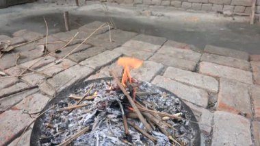 Yanan odun ateşi. Yangın üflenerek alevlendiriliyor. Tahta ateş. Hindistan 'ın kırsal bölgesi.
