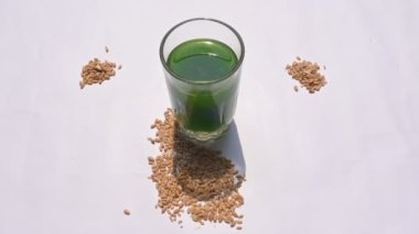 Beyaz arka planda buğday çimi suyu. Yeşil filizlenmiş buğday tanelerinin çimlerinden sağlıklı organik yeşil detoks suyu. Sağlıklı bir içki. Genç buğday ve buğday suyundan yeşil yapraklar.