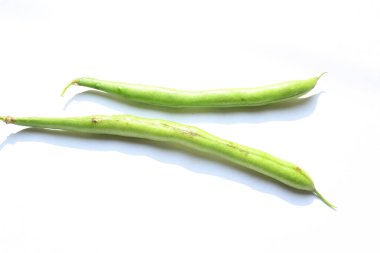Beyaz arka planda yeşil fasulye. Diğer isimleri Fransız fasulyesi, çalı fasulyesi, fasulye, bisküvi, ve Fransız ismi Haricot vert. Dünyanın en popüler sebzesi.. 