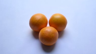 Beyaz arka planda taze turuncu. Rutaceae familyasındaki bir ağacın meyvesi. Portakallarda bulunan ana vitaminler C vitamini, flavonoid ve karotenoidlerdir. Tüm dünyada popüler bir meyvedir. Yavaş çekim videosu.