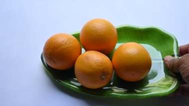 Beyaz arka planda taze turuncu. Rutaceae familyasındaki bir ağacın meyvesi. Portakallarda bulunan ana vitaminler C vitamini, flavonoid ve karotenoidlerdir. Tüm dünyada popüler bir meyvedir. Yavaş çekim videosu.