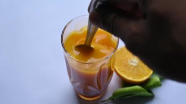 Beyaz arka planda taze portakal suyu. C vitamini, folik asit ve potasyum gibi vitaminler içeren ünlü bir meyve suyu. Sağlıklı bir içki. Meyve suyu. Yavaş çekim videosu. 