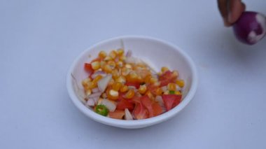 Haşlanmış mısır Chaat. Hint usulü mısır salatası. Tatlı, baharatlı ve keskin. Chaat masala, kavrulmuş kimyon tozu, kırmızı biber tozu, kişniş yaprağı, soğan ve domatesle karıştırılır. Hint yemekleri..