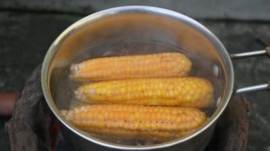 Tatlı mısır kaynatılıyor. Bu insanlar için tam bir yiyecek. Koçanda B1, B5, C, B9, E, A. Haşlanmış mısır gibi birçok vitamin içerir. Sanki dünyanın her yerindeymiş gibi. Yavaş çekim videosu. 