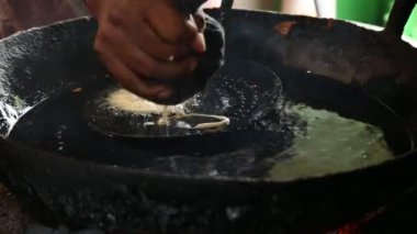 Jalebi yapımı. Hindistan 'ın alt kıtasında popüler bir atıştırmalık. Birçok isim var; jilebi, jilipi, zulbia, mushabak, zlabia ve zalabia. Maida un ve şeker şurubu tarafından yapıldı..