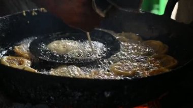 Jalebi yapımı. Hindistan 'ın alt kıtasında popüler bir atıştırmalık. Birçok isim var; jilebi, jilipi, zulbia, mushabak, zlabia ve zalabia. Maida un hamuru ve şeker şurubu tarafından yapılıyor. Yavaş çekim videosu. 