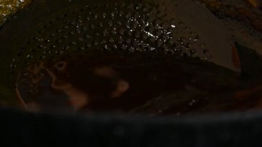 Jalebi yapımı. Hindistan 'ın alt kıtasında popüler bir atıştırmalık. Birçok isim var; jilebi, jilipi, zulbia, mushabak, zlabia ve zalabia. Maida un hamuru ve şeker şurubu tarafından yapılıyor. Yavaş çekim videosu. 