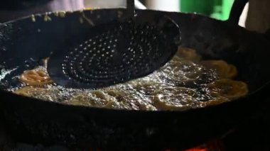 Jalebi yapımı. Hindistan 'ın alt kıtasında popüler bir atıştırmalık. Birçok isim var; jilebi, jilipi, zulbia, mushabak, zlabia ve zalabia. Maida un hamuru ve şeker şurubu tarafından yapılıyor. Yavaş çekim videosu. 