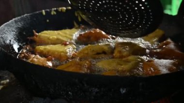 Ekmek pakora kızgın yağda kızartılıyor. Ekmeği patatesle doldurup nohut hamuruna batırıp kızartarak yapılır. Hindistan 'ın popüler atıştırması. Yavaş çekim videosu. 