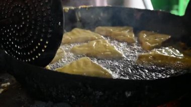 Ekmek pakora kızgın yağda kızartılıyor. Ekmeği patatesle doldurup nohut hamuruna batırıp kızartarak yapılır. Hindistan 'ın popüler atıştırması. Yavaş çekim videosu. 