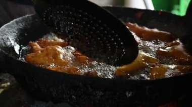 Ekmek pakora kızgın yağda kızartılıyor. Ekmeği patatesle doldurup nohut hamuruna batırıp kızartarak yapılır. Hindistan 'ın popüler atıştırması. Yavaş çekim videosu. 