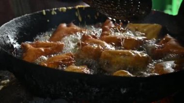 Ekmek pakora kızgın yağda kızartılıyor. Ekmeği patatesle doldurup nohut hamuruna batırıp kızartarak yapılır. Hindistan 'ın popüler atıştırması. Yavaş çekim videosu. 