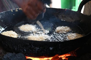 Jalebi yapımı. Hindistan 'ın alt kıtasında popüler bir atıştırmalık. Birçok isim var; jilebi, jilipi, zulbia, mushabak, zlabia ve zalabia. Maida un ve şeker şurubu tarafından yapıldı..