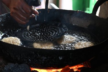 Jalebi yapımı. Hindistan 'ın alt kıtasında popüler bir atıştırmalık. Birçok isim var; jilebi, jilipi, zulbia, mushabak, zlabia ve zalabia. Maida un ve şeker şurubu tarafından yapıldı..