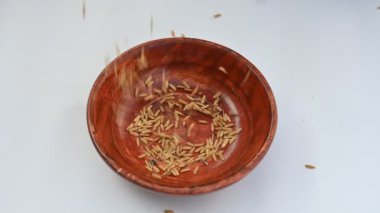 Ahşap kase çeltik dolu. Kahverengi pirinç ya da değirmensiz pirinç deniyor. Pirinç kabuğu çeltik ağacından çıkarılarak üretilir. Çeltik tohumu veya pirinç tohumu. 