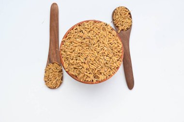 Ahşap kase çeltik dolu. Kahverengi pirinç ya da değirmensiz pirinç deniyor. Pirinç kabuğu çeltik ağacından çıkarılarak üretilir. Çeltik tohumu veya pirinç tohumu. 