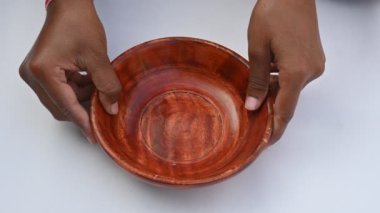 Beyaz arka planda ahşap kase. Kase, basit ve yuvarlaktır. Bu, kasenin doğal dokusuna ve formuna odaklanır. Yüksek dinamik aralıklarla çekilir..