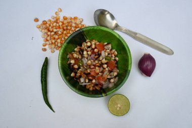 Izgara mısır gevreği. Hint usulü mısır salatası. Tatlı, baharatlı ve keskin. Chaat masala, kavrulmuş kimyon tozu, kırmızı biber tozu, kişniş yaprağı, soğan ve domatesle karıştırılır. Hint yemekleri..